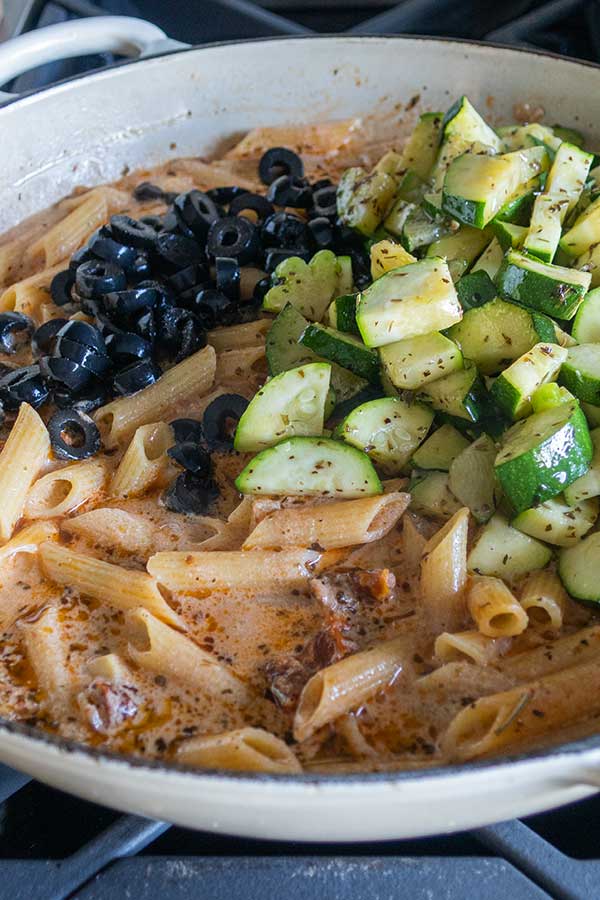 adding olives and zucchini to tuscan pasta dish, gluten free