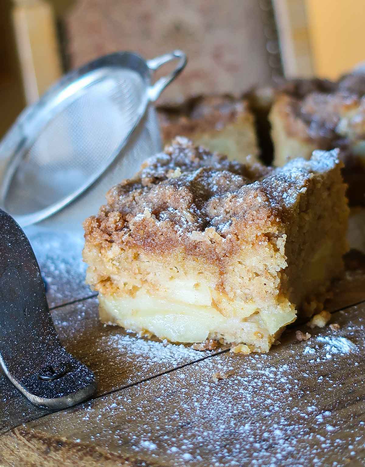 slice of vegan apple streusel cake dusted with powdered sugar