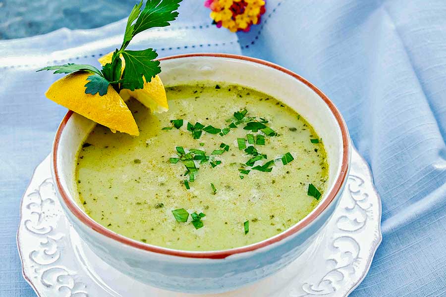 vegetarian chickpea parsley soup in a bowl with lemon wedges