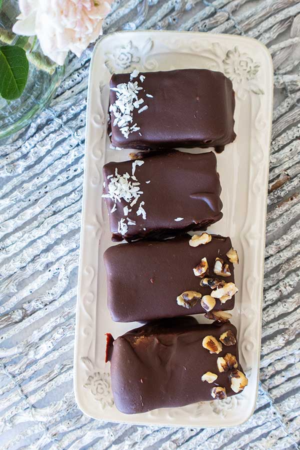 4 chocolate covered coconut bars on a white tray