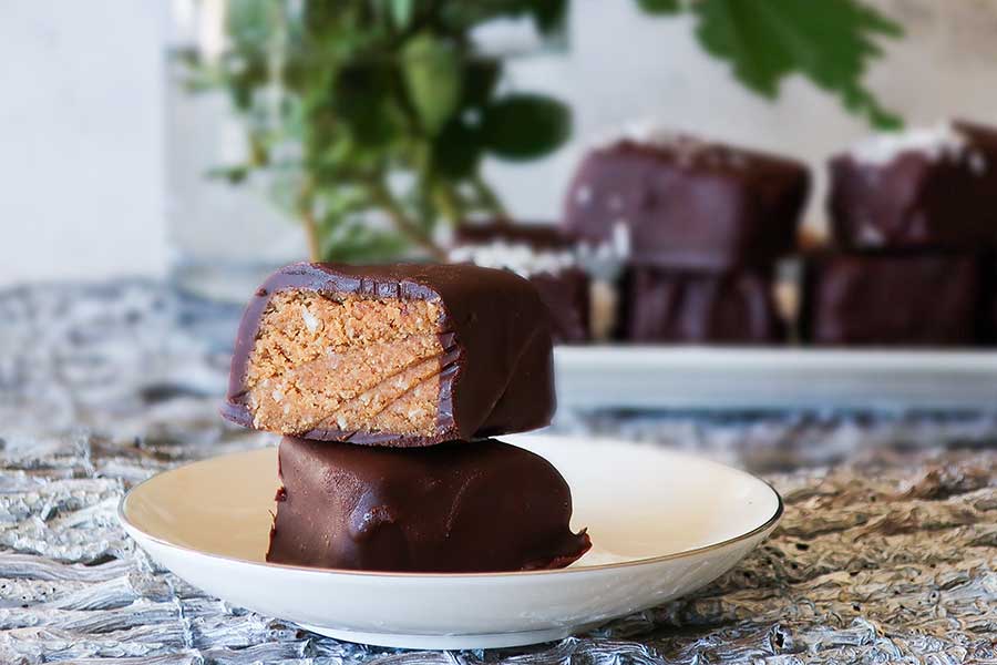 sliced chocolate covered coconut bars on a plate