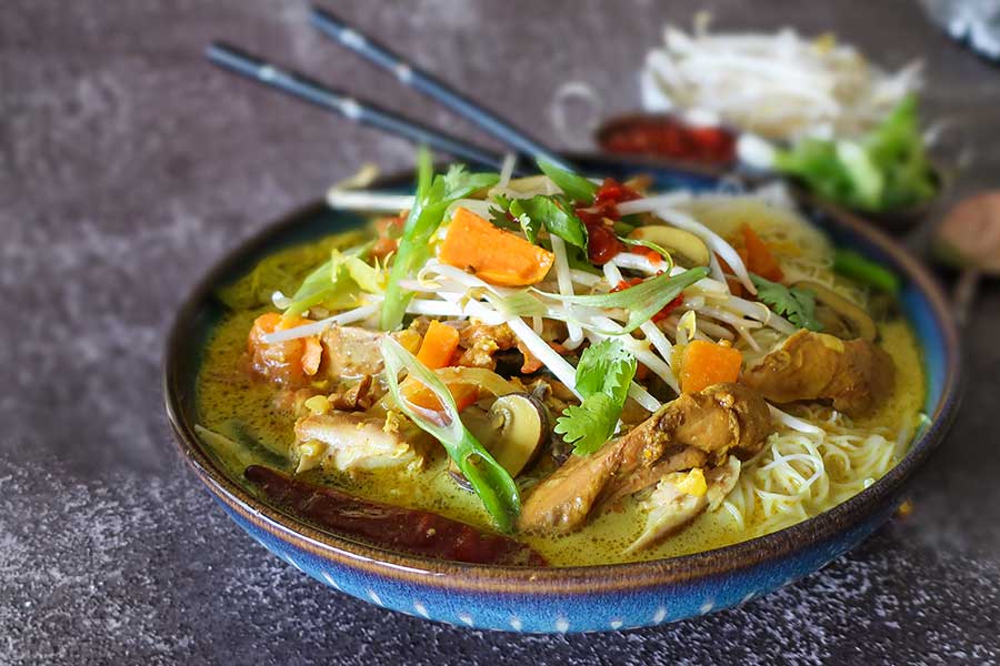 Malaysian soup with veggies and noodles in a bowl