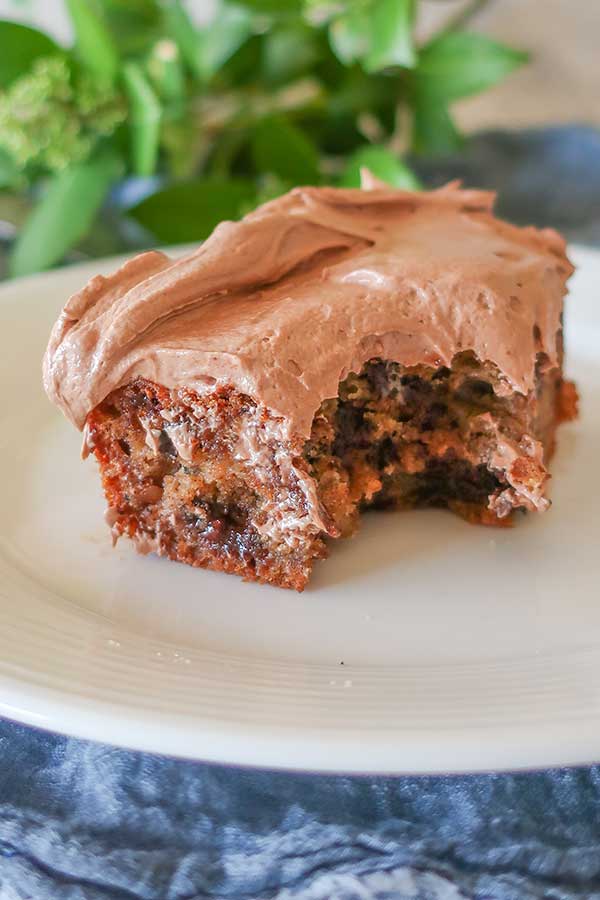 slice of gluten free banana snacking cake with Nutella frosting on a plate