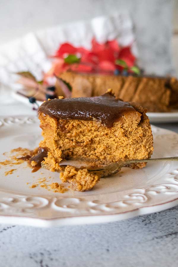 slice of salted caramel chai pumpkin cheesecake on a dessert plate