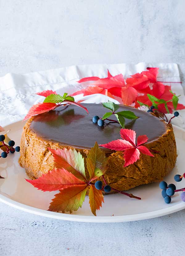 decorated chai pumpkin cheesecake with salted caramel on a platter