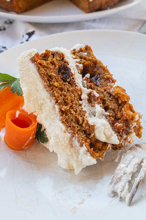 side view of a slice of gluten free cake with frosting on a plate