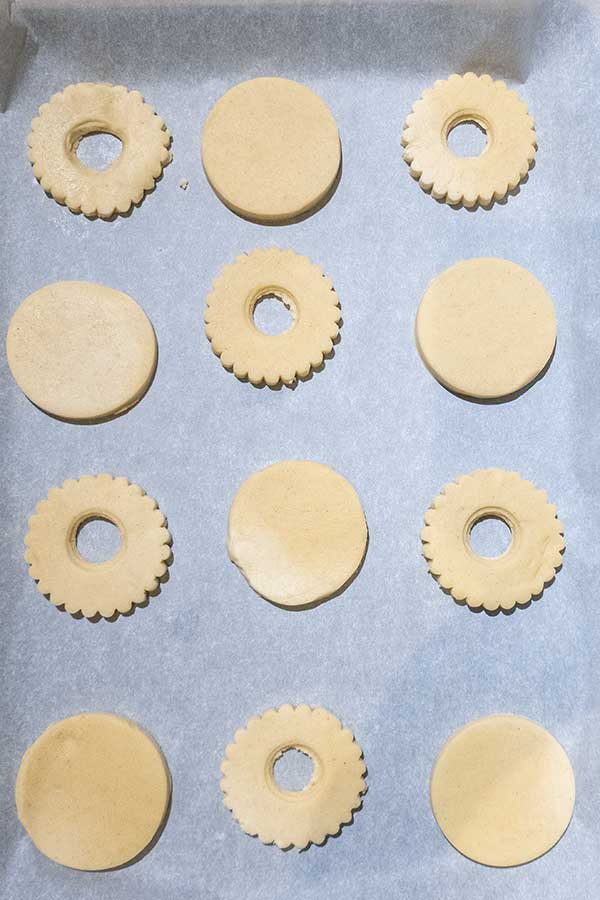 linzer cookie dough shapes on parchment paper