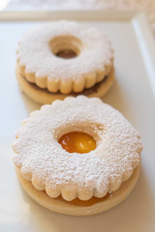 2 linzer cookies with jam filling on a plate