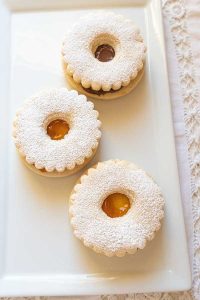 3 gluten free linzer cookies on a desert plate