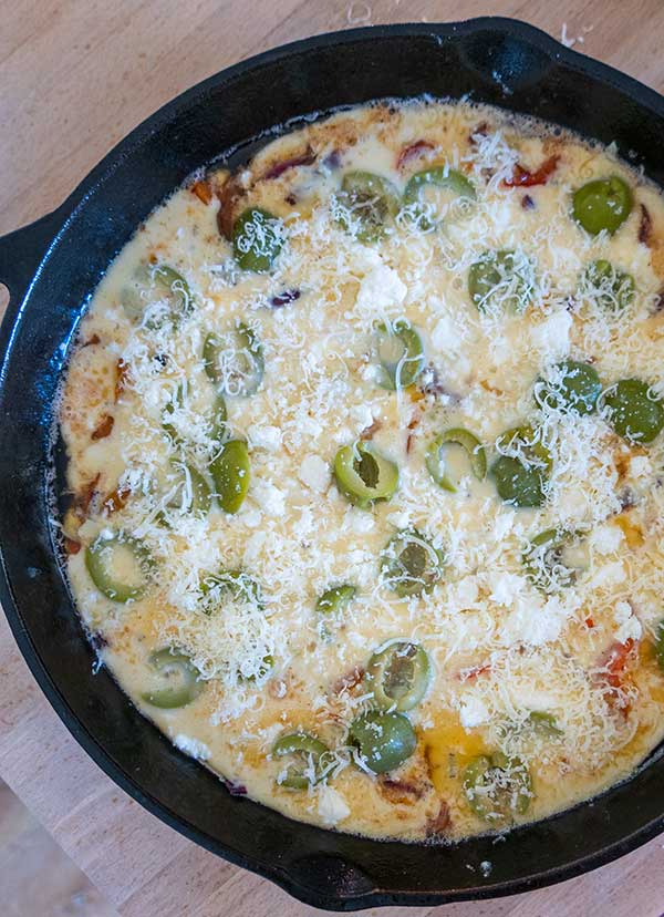 batter in a cast iron skillet with mix-ins