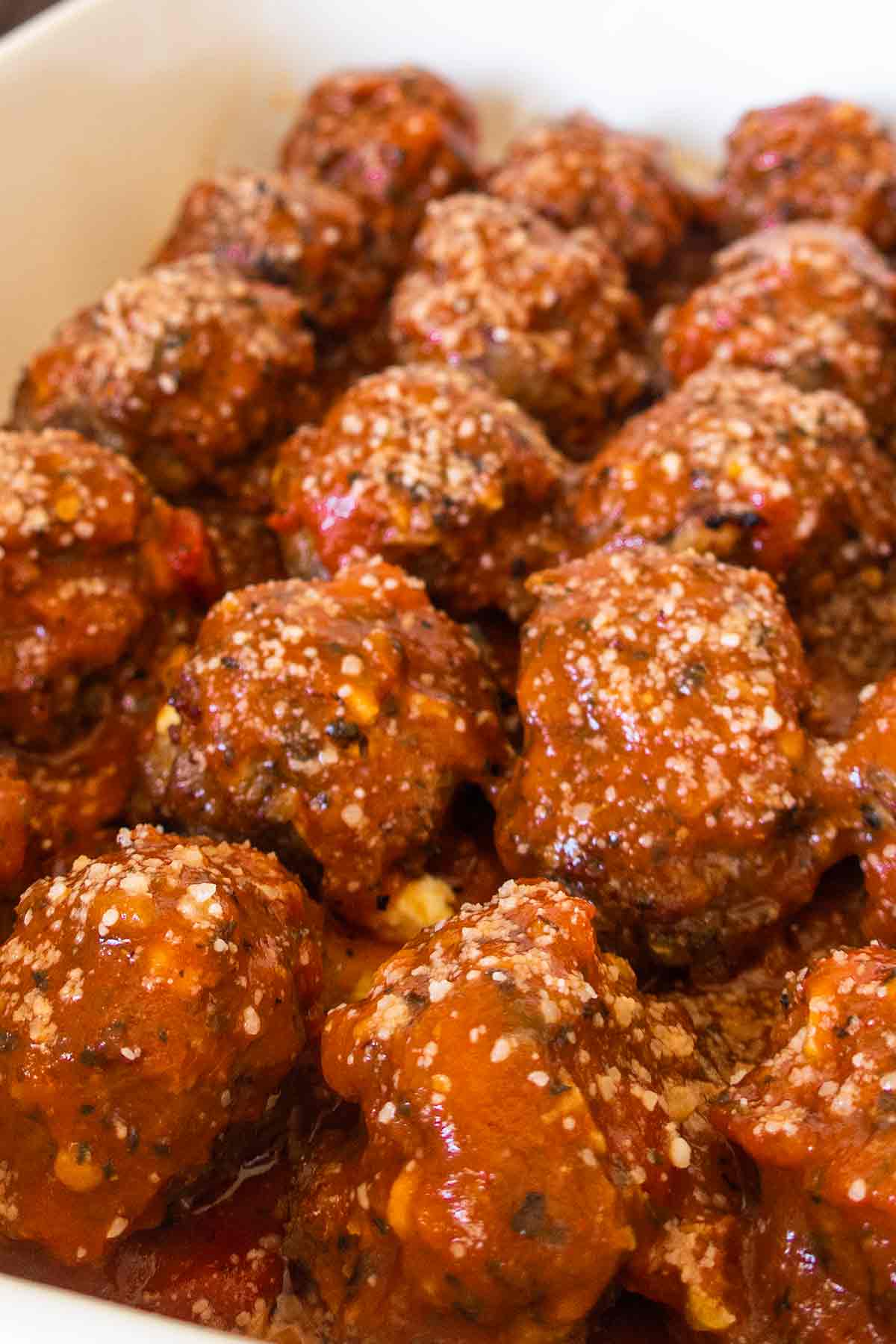 meatballs in a baking dish coated with tomato sauce