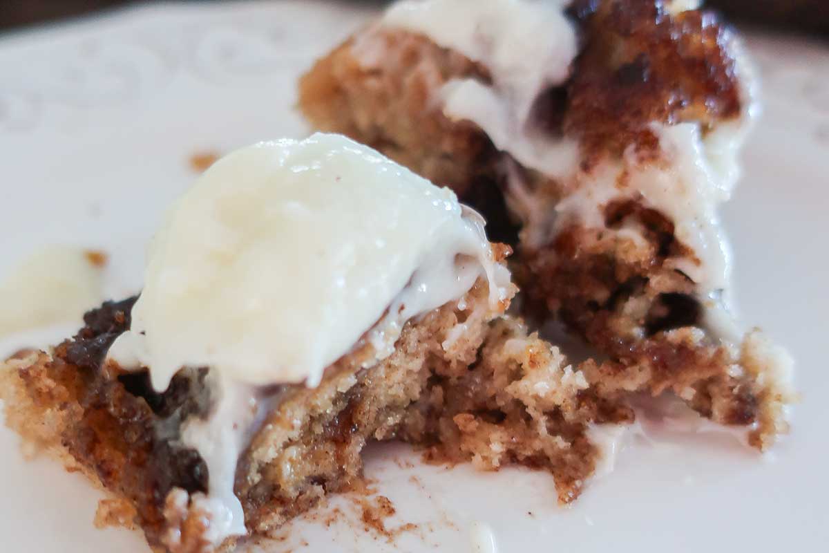 slice of gluten and egg free frosted gingerbread coffee cake on a small plate