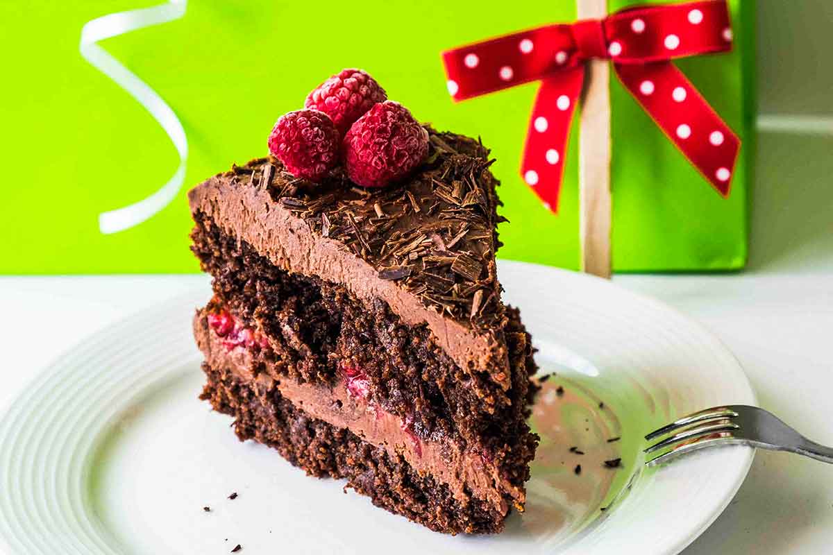 a slice of gluten free vegan chocolate cake with icing on a plate