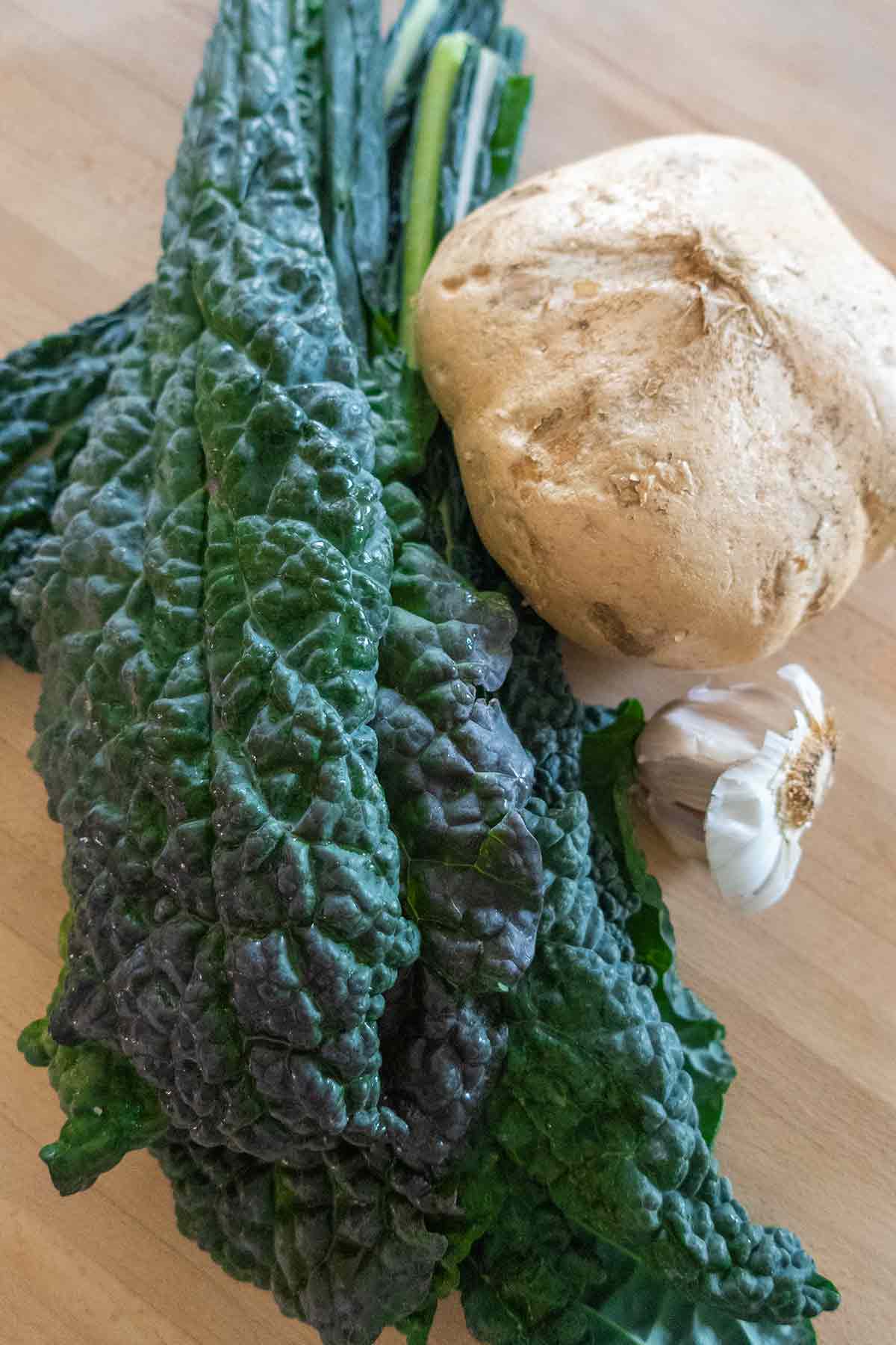 tuscan kale, jicama and garlic on a cutting board