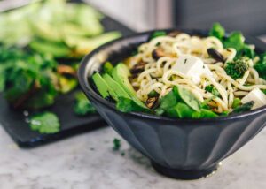 vegetarian noodle dish in a bowl with avocado slices