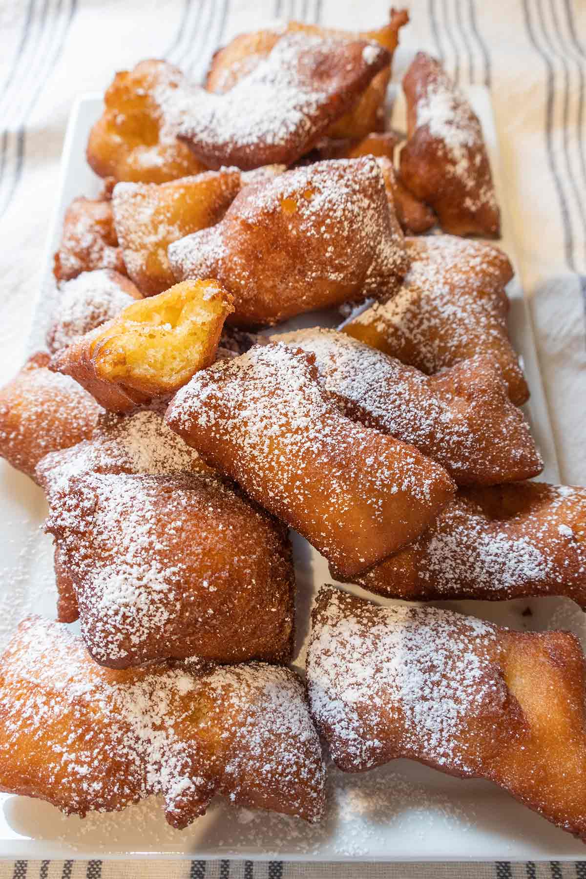 beignets dusted with powdered sugar on a platter