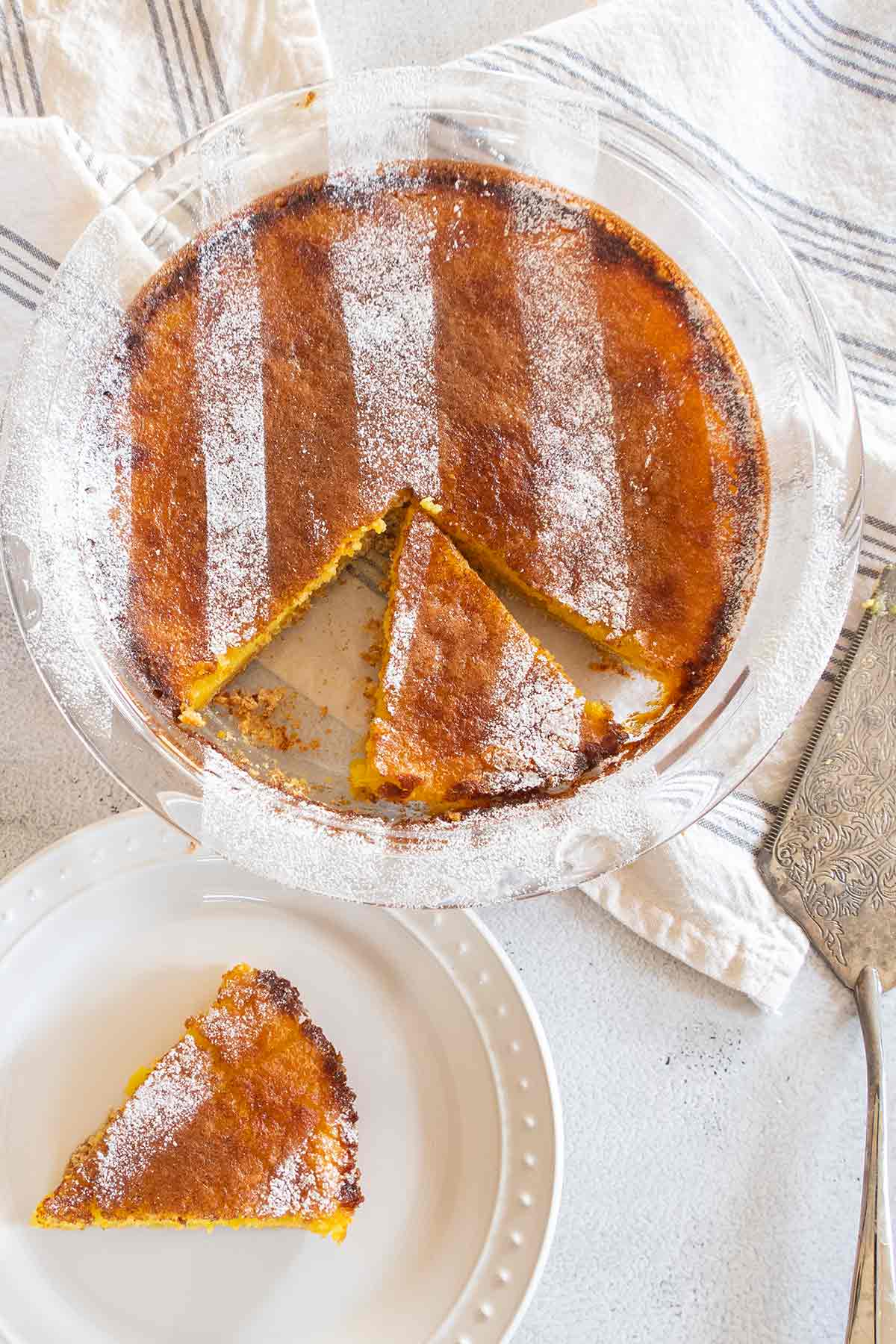 sliced pie in a glass pie dish with a slice on a desert plate