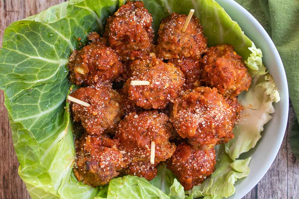 baked Italian meatballs in a bowl lined with cabbage leaf