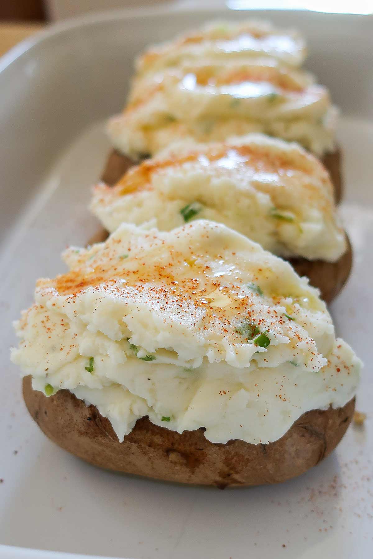 filled potato skins with meat mixture and topped with seasoned mashed potatoes