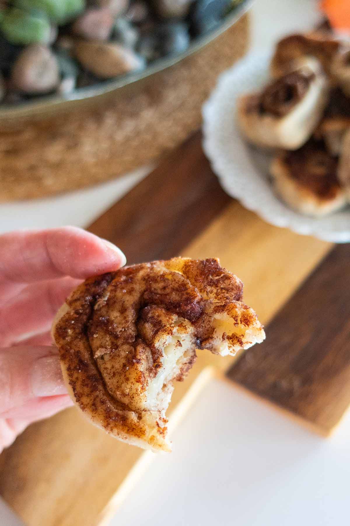 holding half a pie crust cookie showing the cinnamon sugar in the center of the cookie