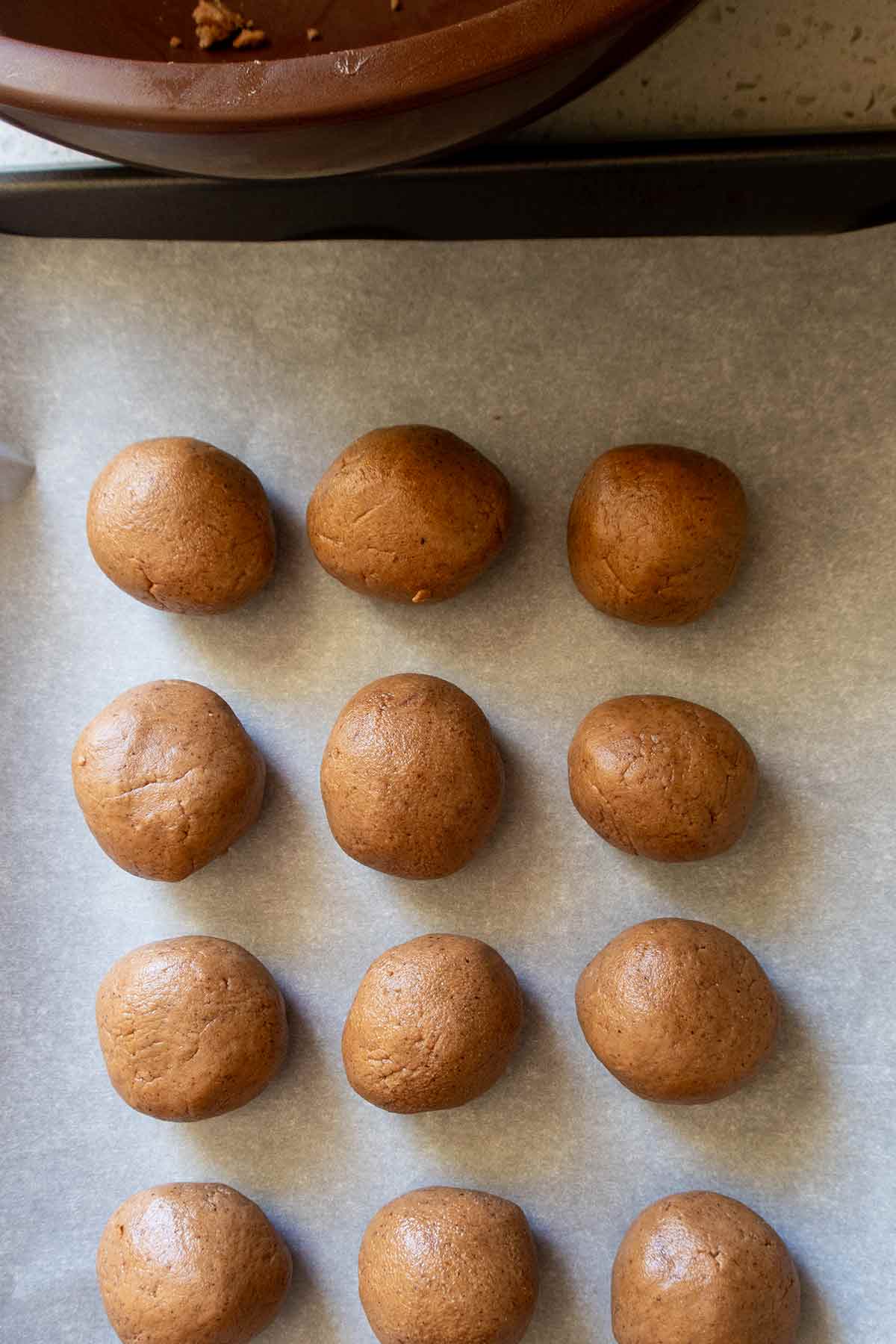 shaped buckeye cookies into balls on a baking sheet
