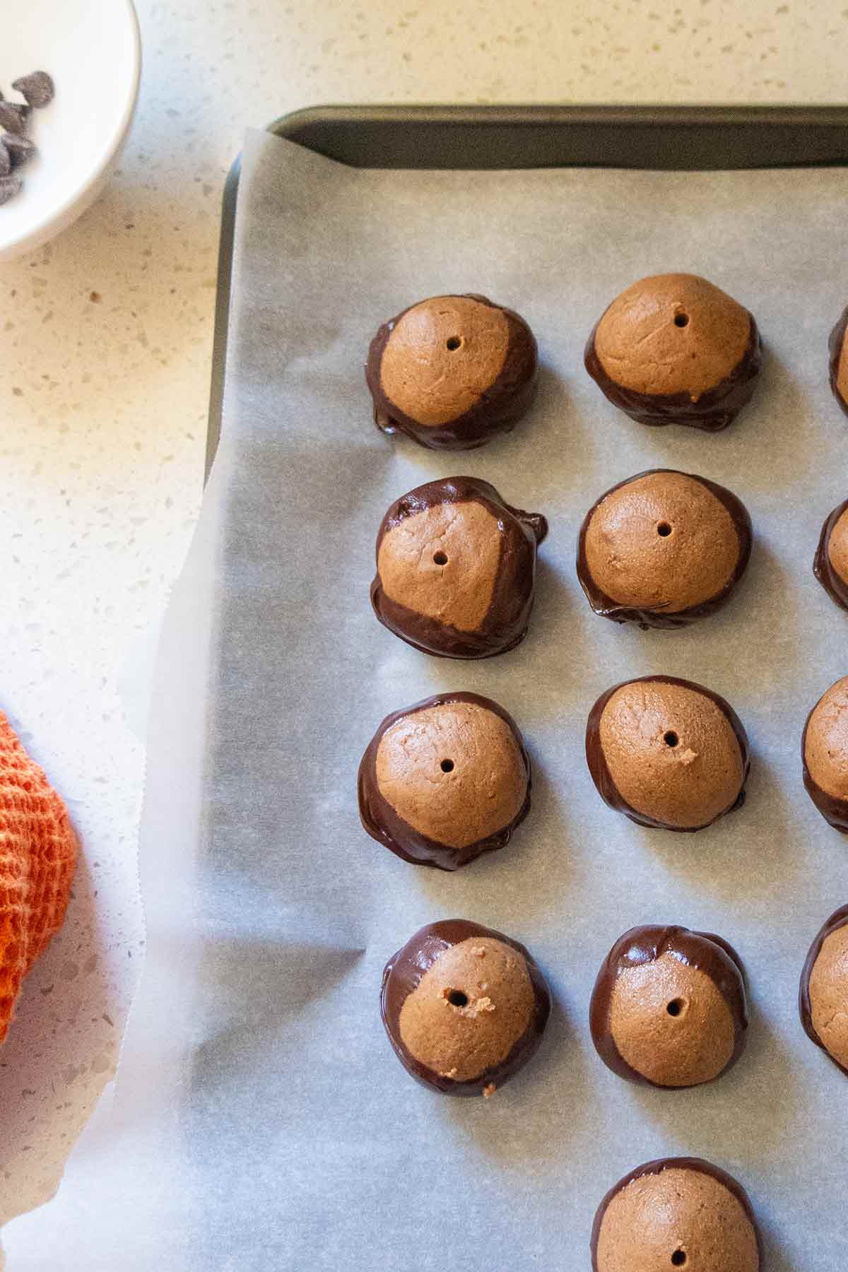 cookies dipped in chocolate on a baking sheet lined with parchment paper