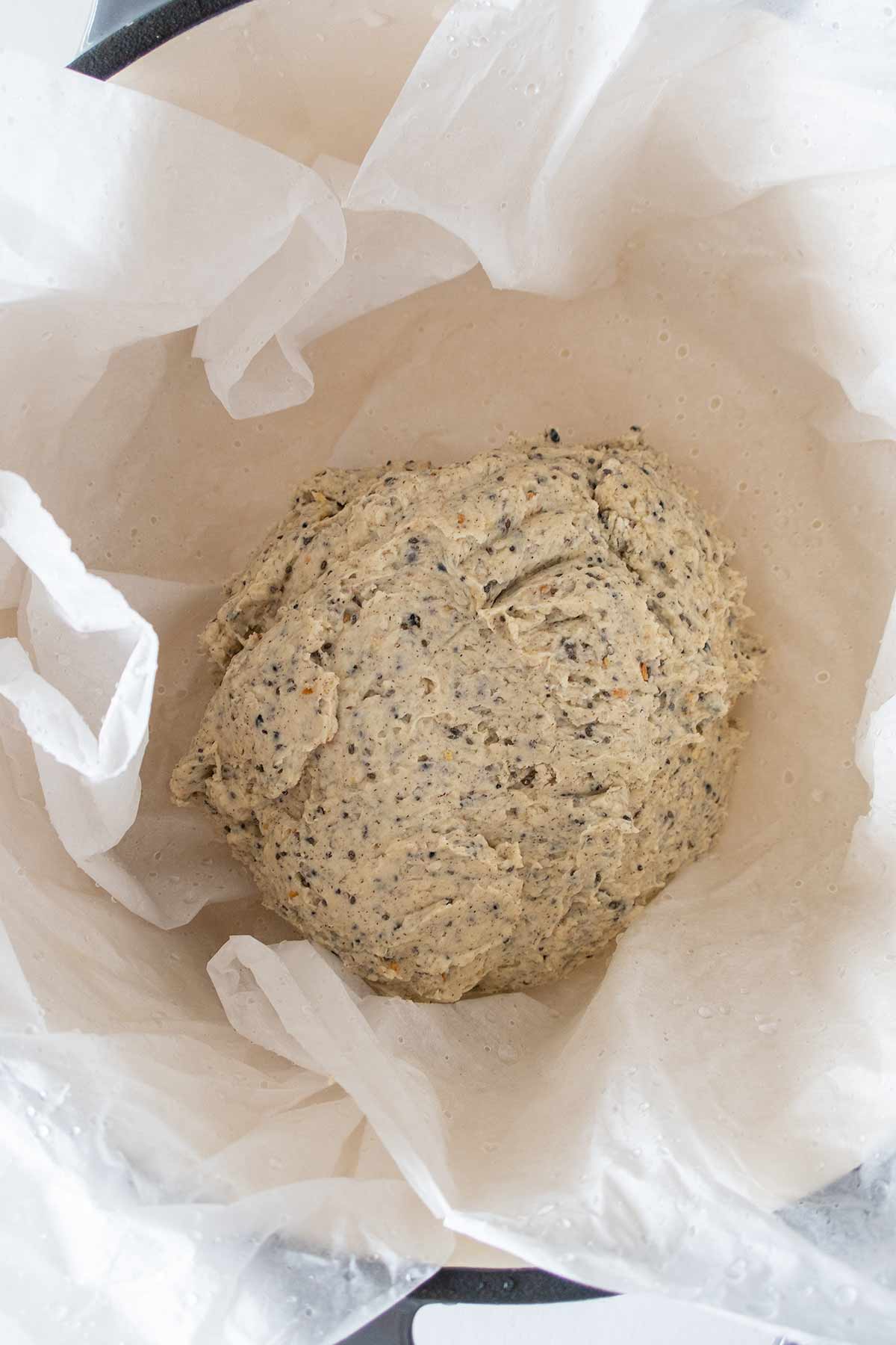 peasant bread dough in a cast iron pot lined with wet parchment paper