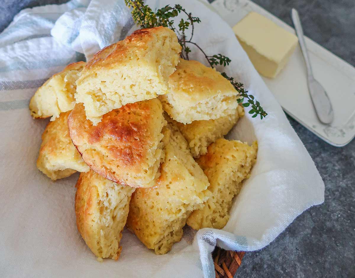 gluten free milk rolls in a towel with butter dish on the side