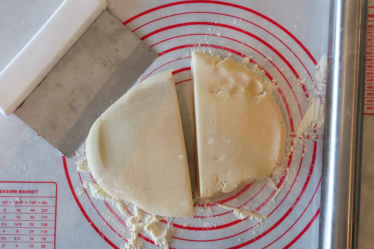 halved chilled disc of pastry dough on dusted working surface