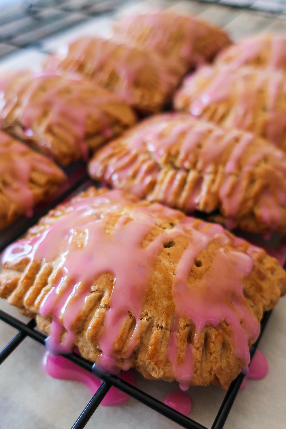 glazed baked pastries with blueberry icing on a cooling rack