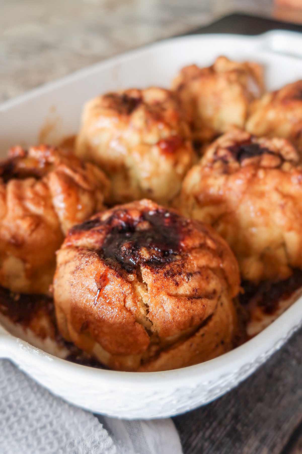 gluten free baked apple dumplings with sauce in a baking dish