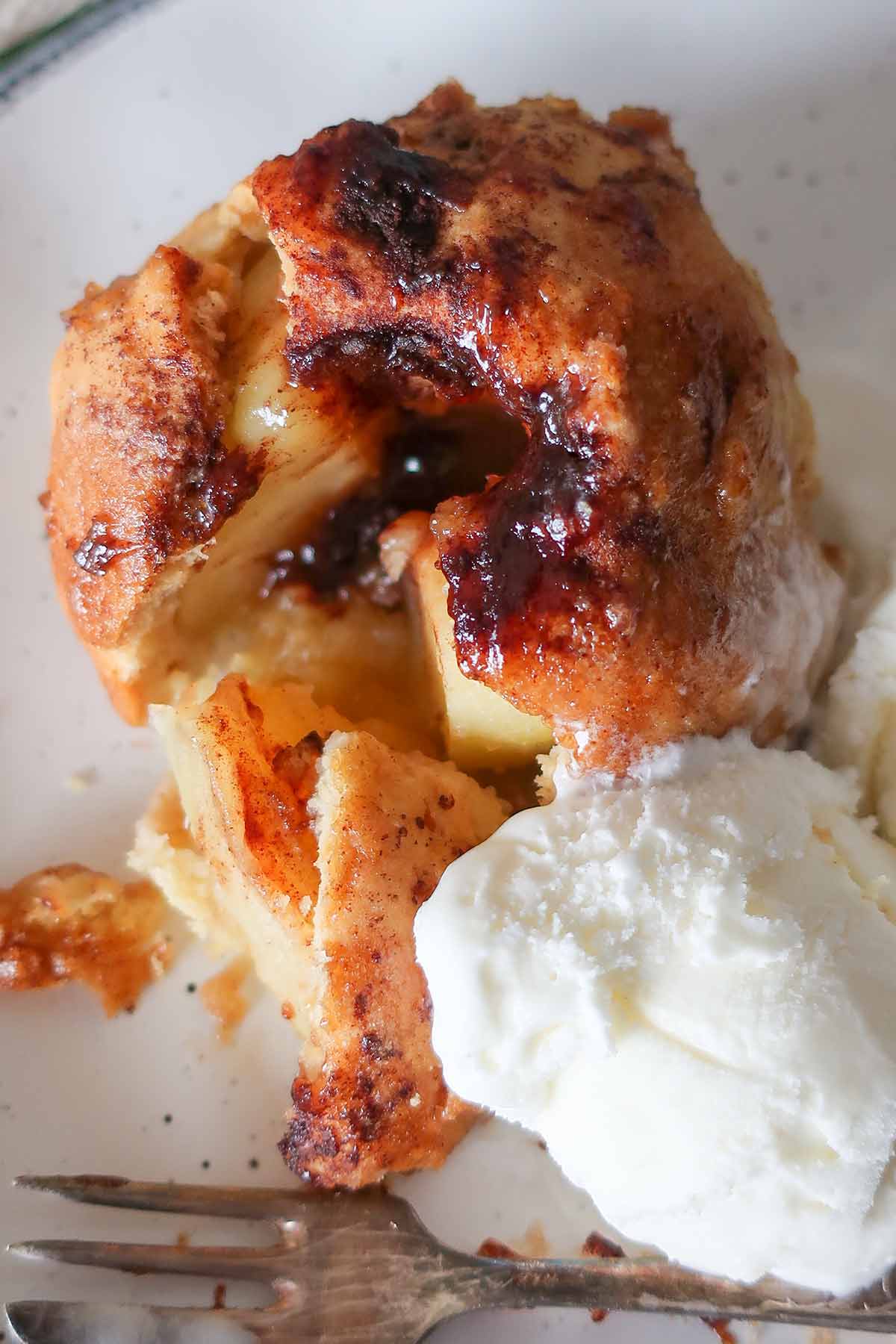 close up of apple dumpling on a plate with ice cream