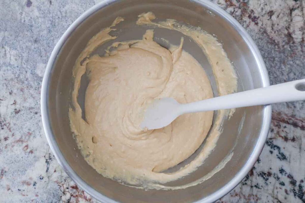 snacking cake batter using egg replacer in a bowl with spatula