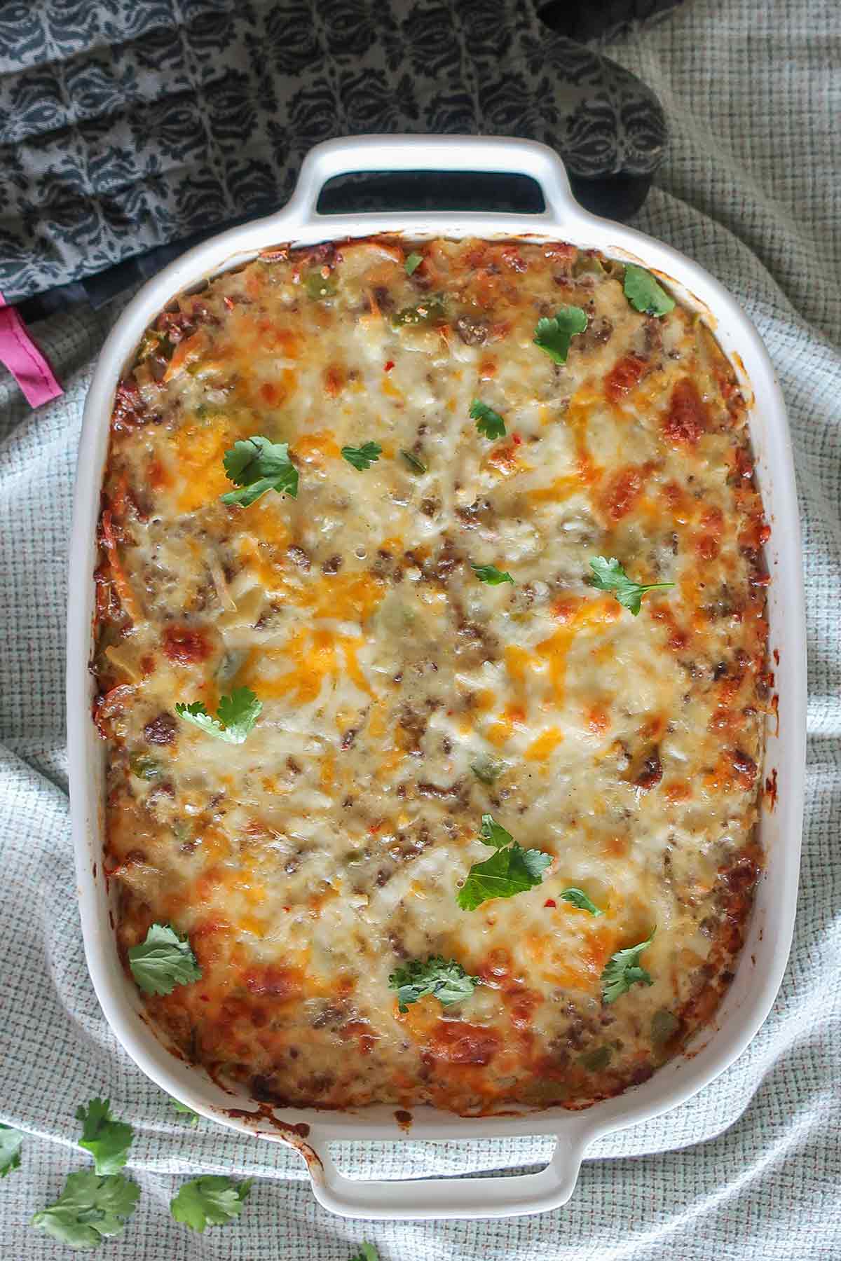 showcasing cheese topping on a baked sausage casserole in a dish