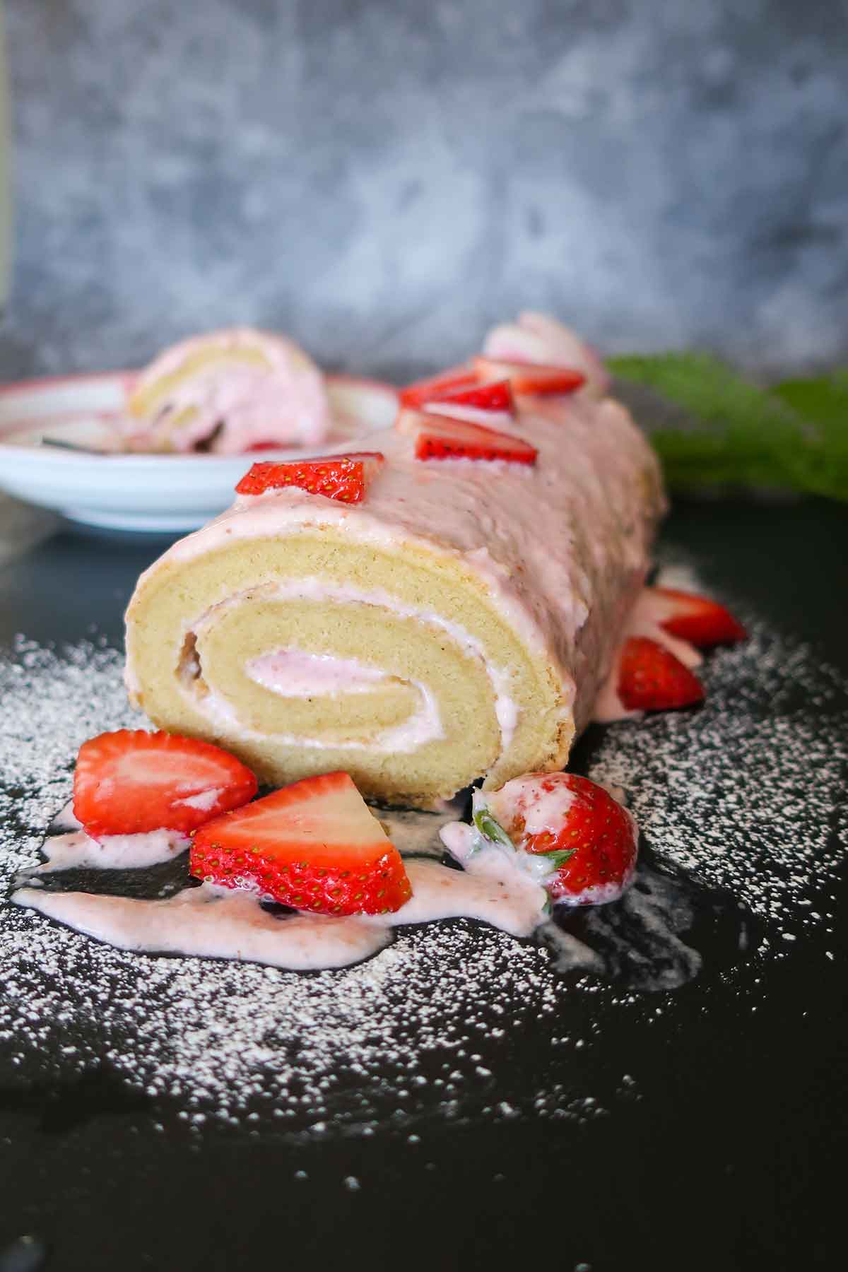 whole strawberry cheesecake jelly roll decorated with strawberries