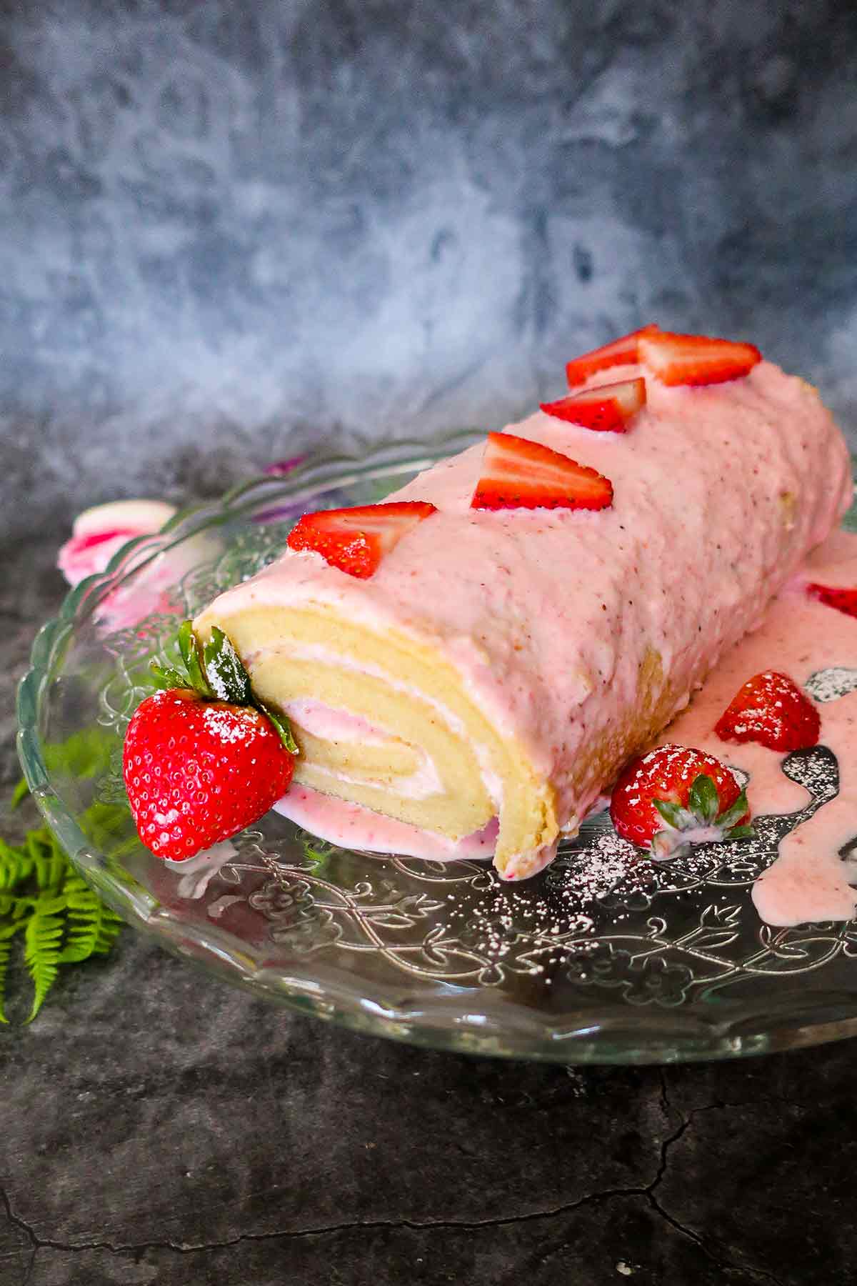 gluten free jelly roll cake decorated with strawberries on a platter