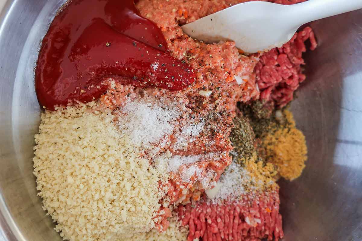 ingredients for gluten free meatloaf in a bowl, spices, breadcrumbs, ketchup