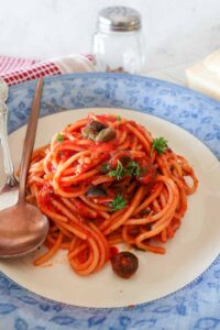 a serving of gluten free pasta puttanesca on a plate