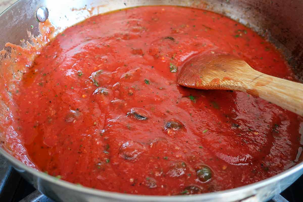 puttanesca sauce simmering in a skillet