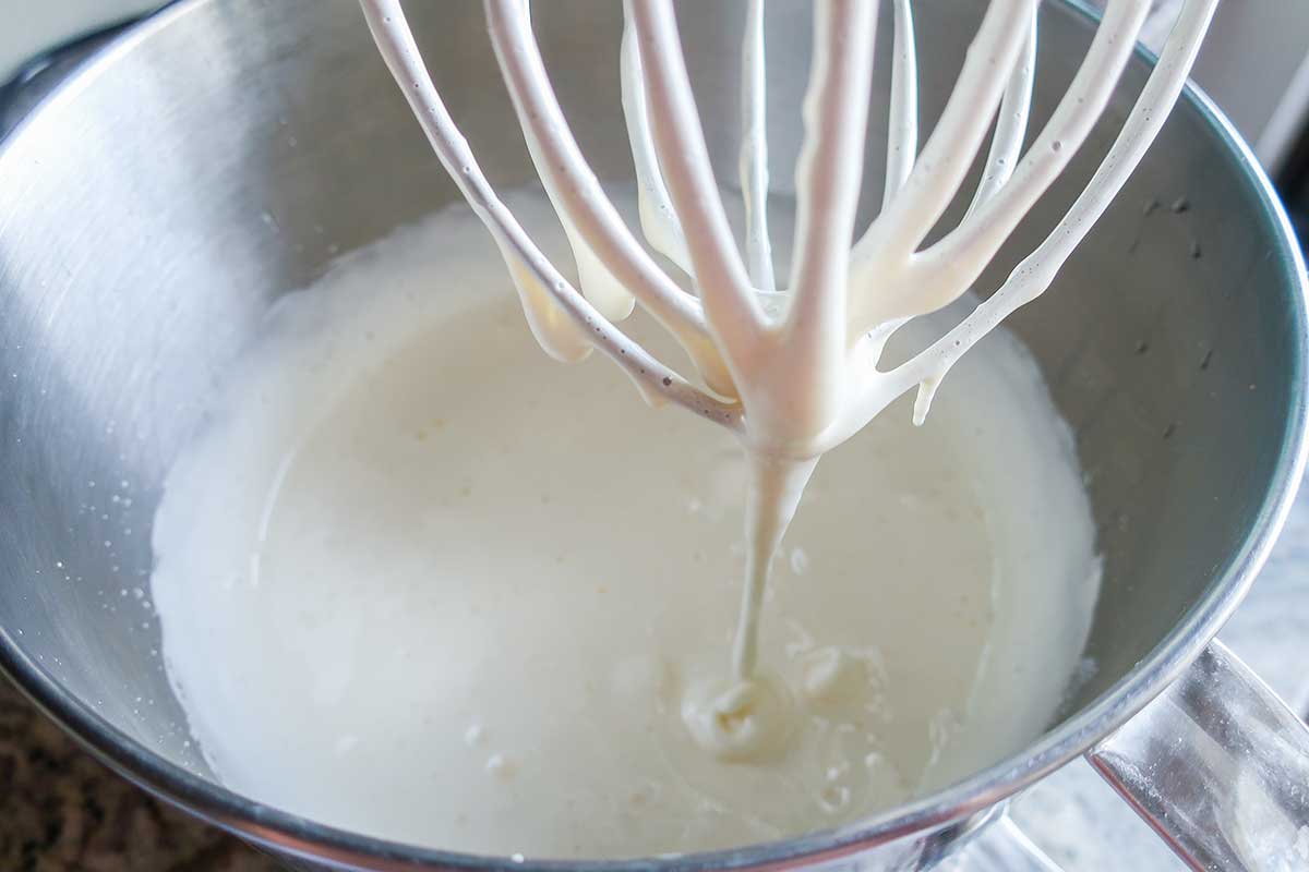 whipped lemon custard mixture in a bowl with a whisk