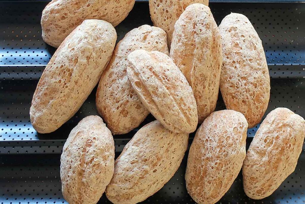 stacked baked rolls on a baguette pan