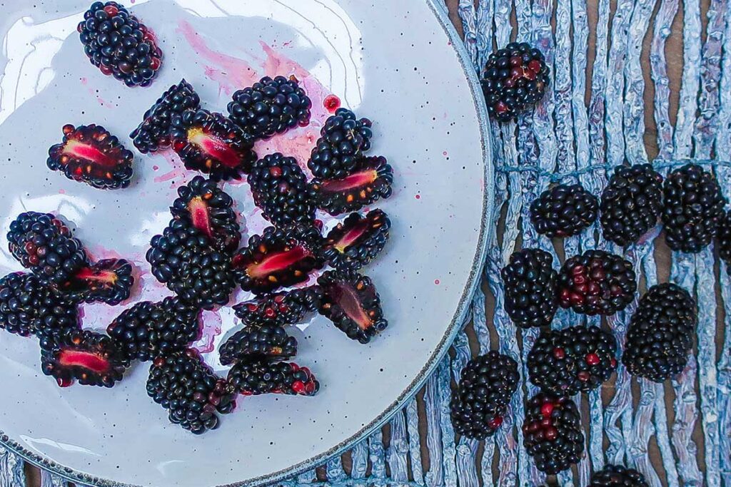 halved blackberries on a plate