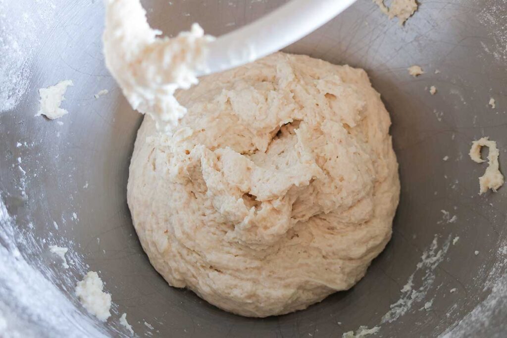 yeasted dough in a bowl showing a dough hook