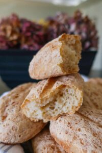 stacked gluten free portuguese rolls in a basket