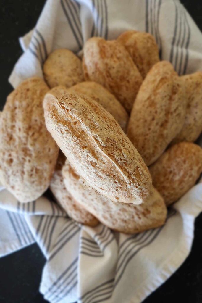 top view of Portuguese rolls in a basked lined with a towel