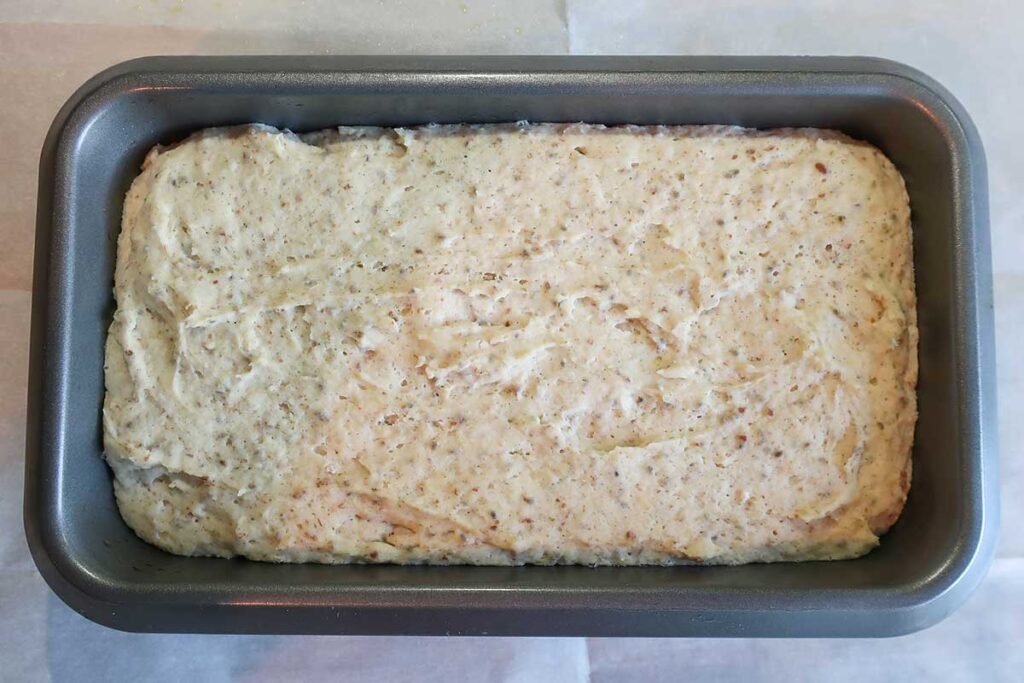 gluten free bread dough in a loaf pan after rising