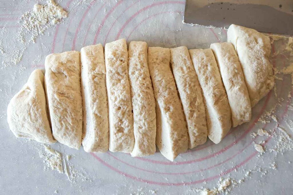 dough divided into 10 pieces on a working surface dusted with flour