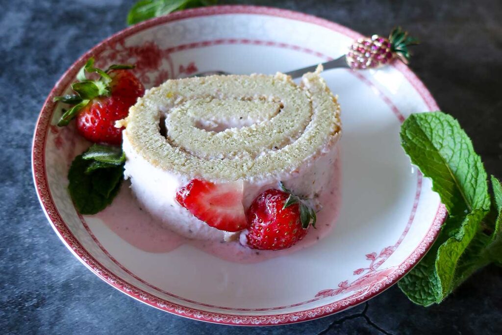 a slice of strawberry jelly roll on a dessert plate