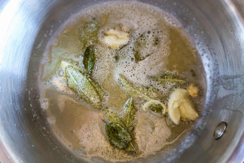 cooking fresh sage and garlic with butter in a saucepan
