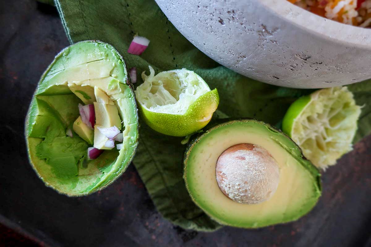 halved avocado, chopped red onion with lime wedges to add to skillet burrito meal